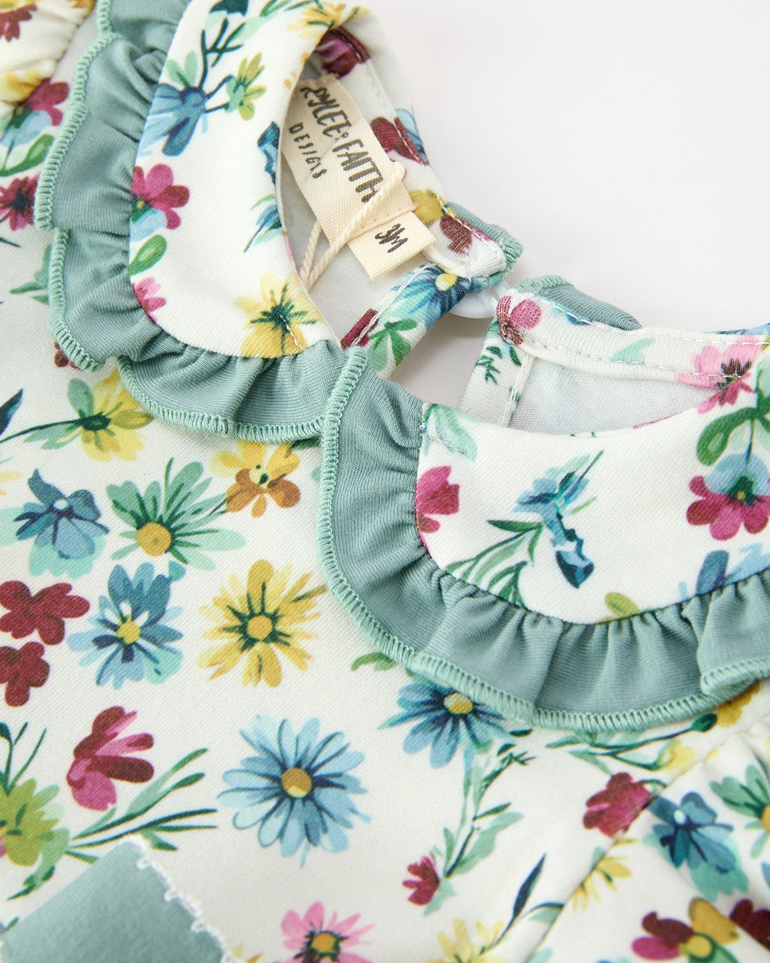 Floral girls dress with ruffle collar and round neckline detail
