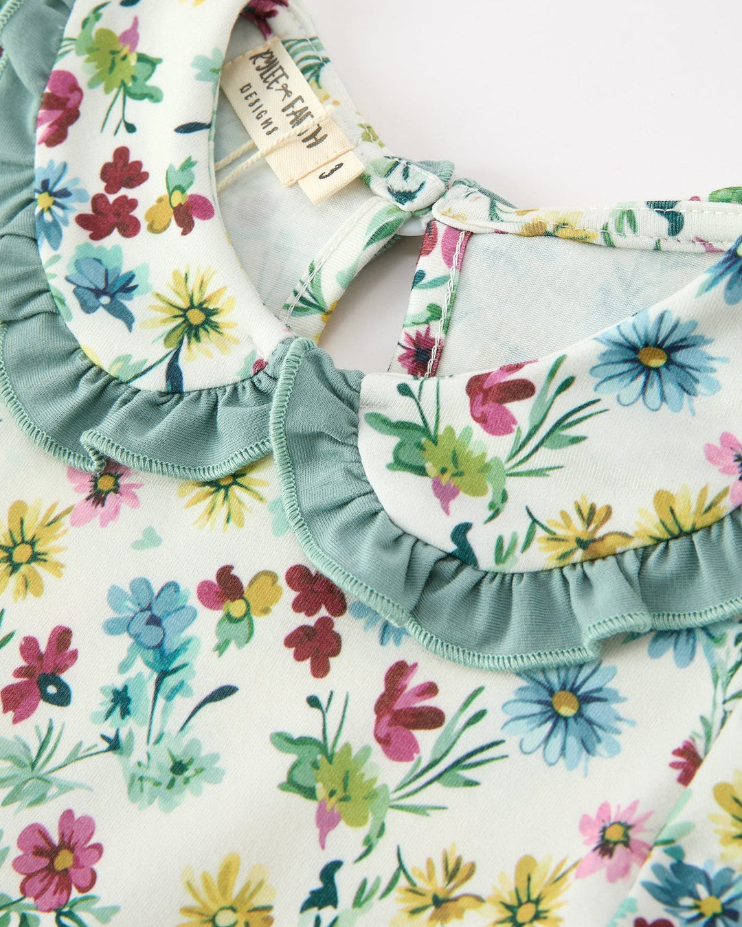 Floral girls dress neckline with mint petal ruffle trim and keyhole button opening