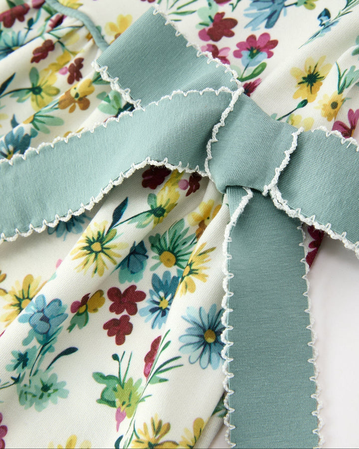 Floral dress detail with scalloped mint-edged ruffle seams at skirt waist