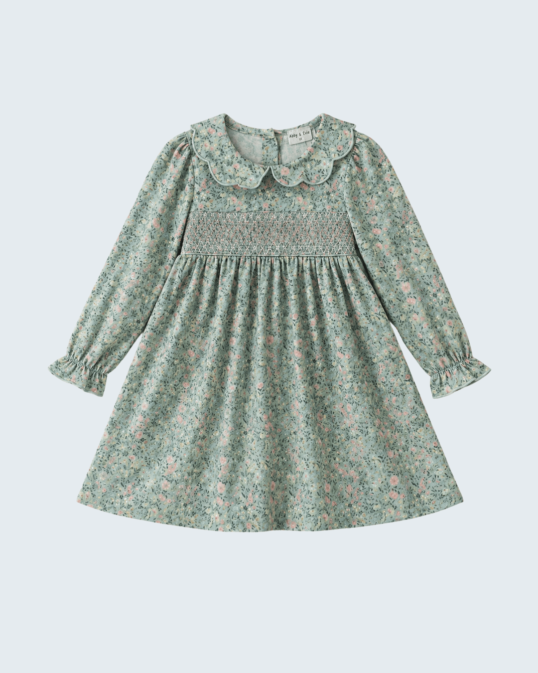 Green floral smocked dress with scalloped Peter Pan collar and long sleeves.
