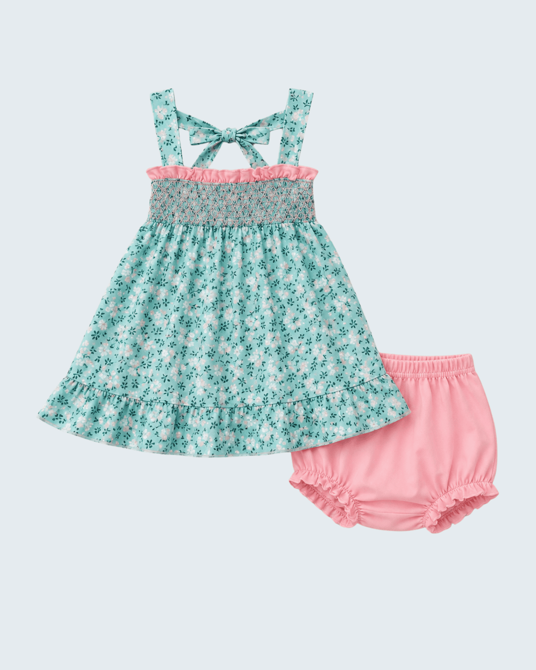 A toddler girl's two-piece outfit set featuring a sleeveless ruffled dress in a mint green and white floral print with a pink ruffle trim and a matching bow at the back of the neckline, paired with pink bloomers, shown on a solid light gray background.
