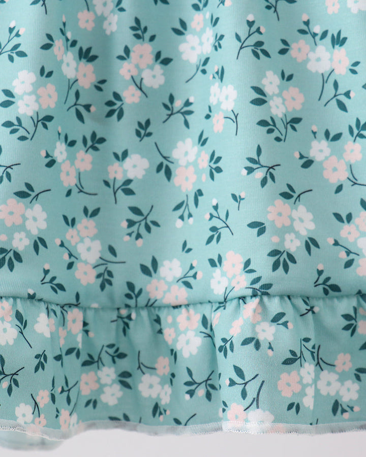 Green floral ruffle skirt fabric with smocked waistband, close-up