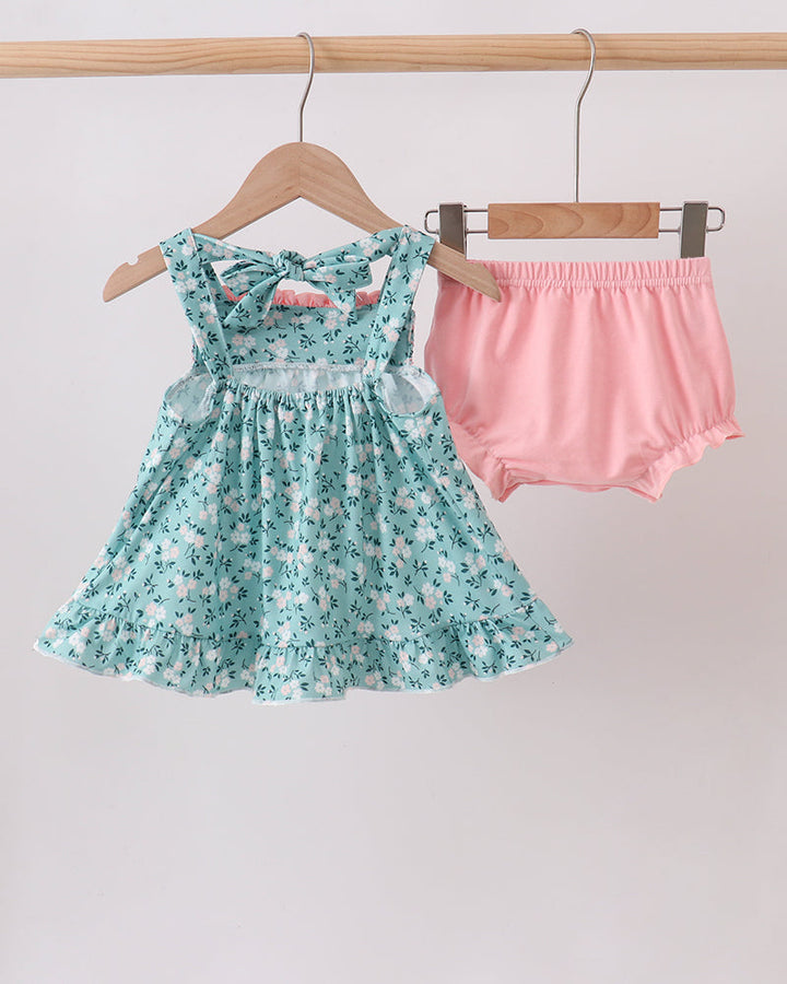 Green floral smocked ruffle dress with pink bloomers, set shown together on hangers