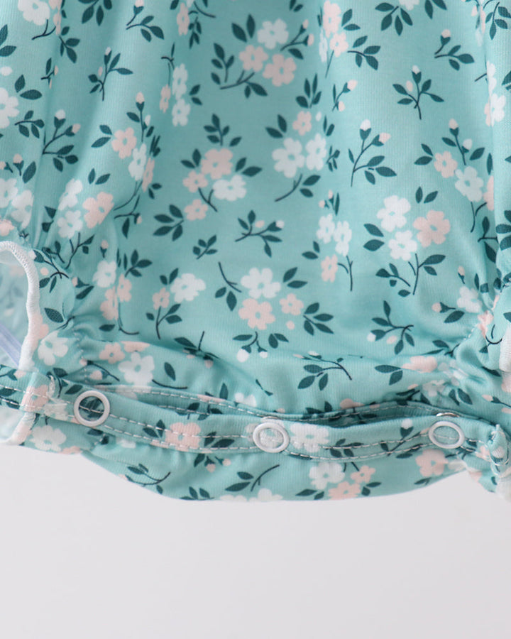 Turquoise floral bubble romper with buttoned bottom and gathered waist ruffle