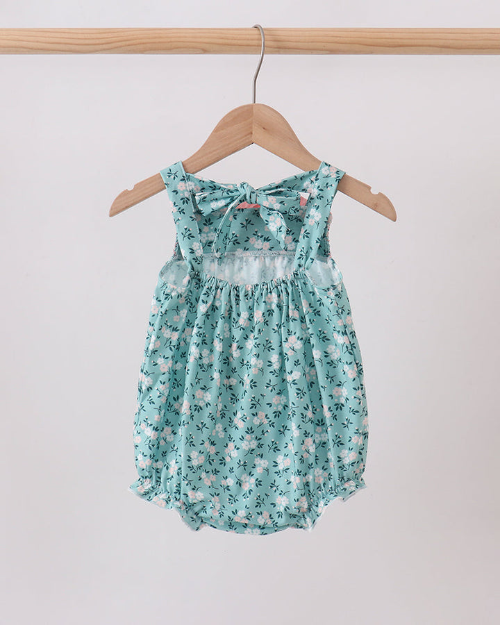 Turquoise floral smocked bubble romper with bow at neckline and flutter ruffle straps