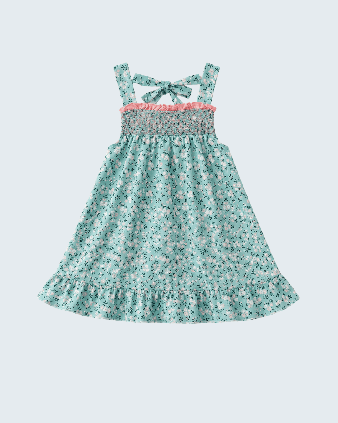 A toddler girl's sleeveless dress with a green and white floral print, featuring a smocked bodice, a pink ruffle trim, and tie straps on a light gray background.