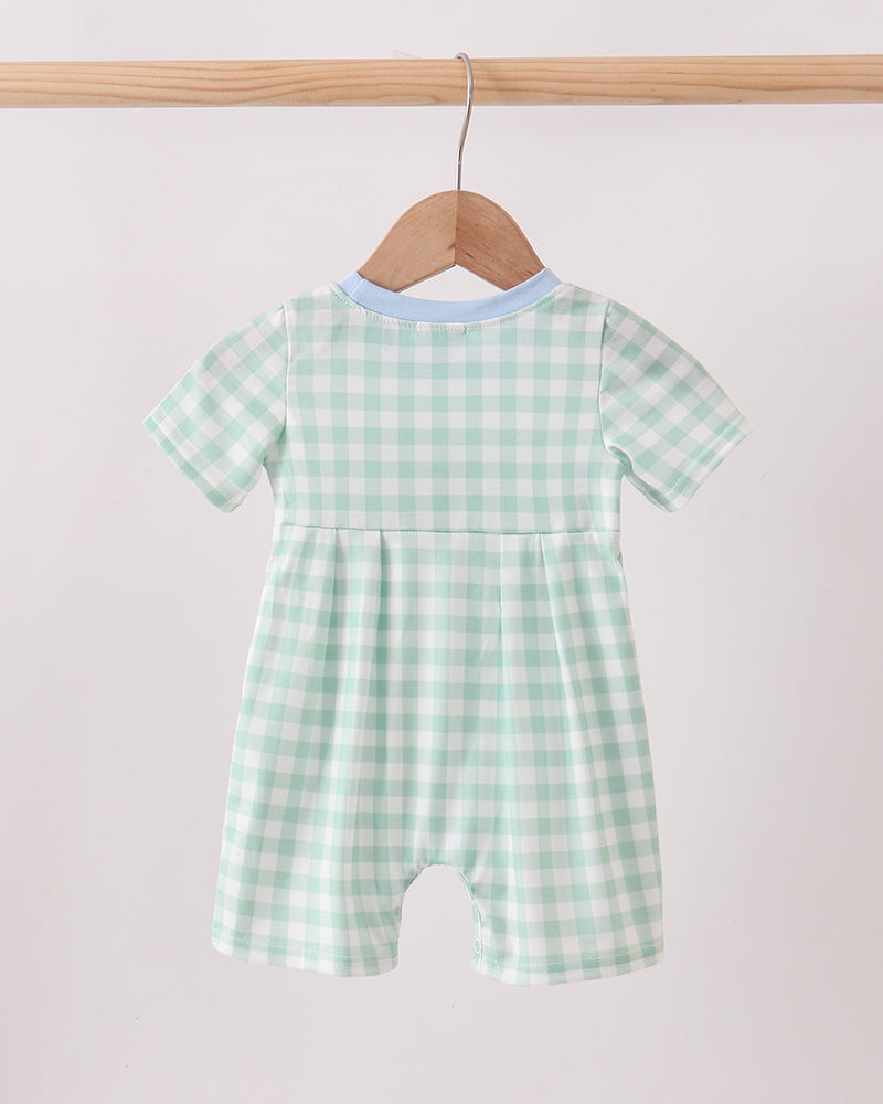 Green Golf Embroidered Romper on wooden hanger.