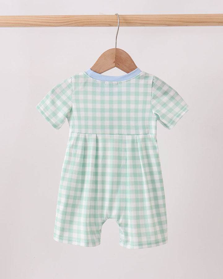 Green Golf Embroidered Romper on wooden hanger.