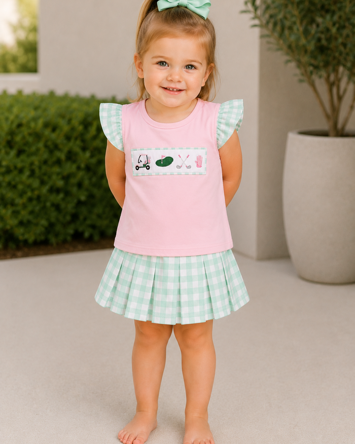 Girl is standing by a building with her hands behind her back