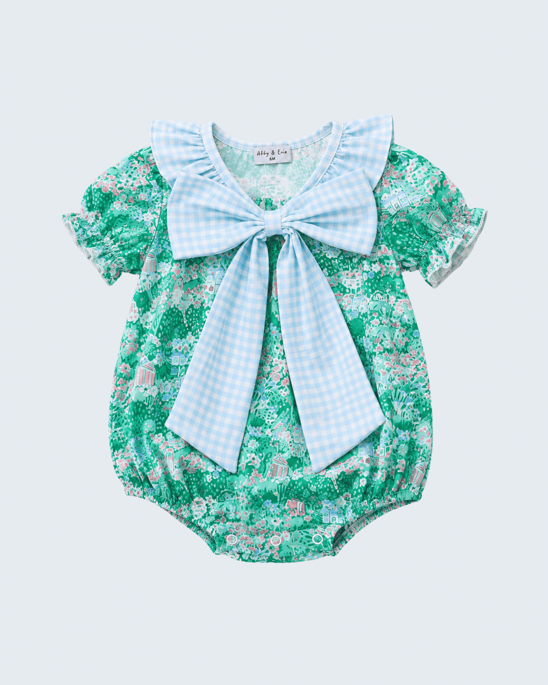 Green floral baby romper with a large blue bow on a light gray background
