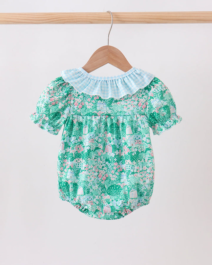 Green floral baby romper on a wooden hanger against a white background