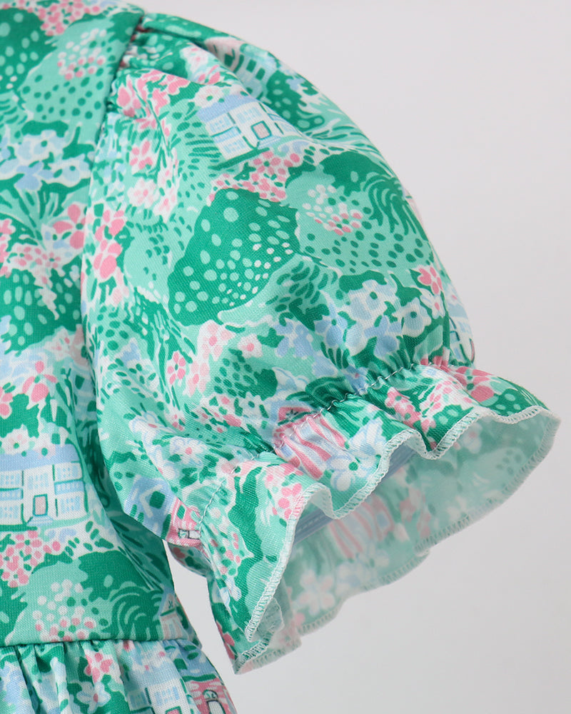 Green floral dress with ruffled hem on a white background