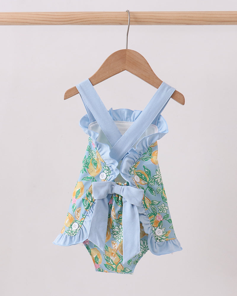 Floral baby romper with blue straps on a hanger against a white background