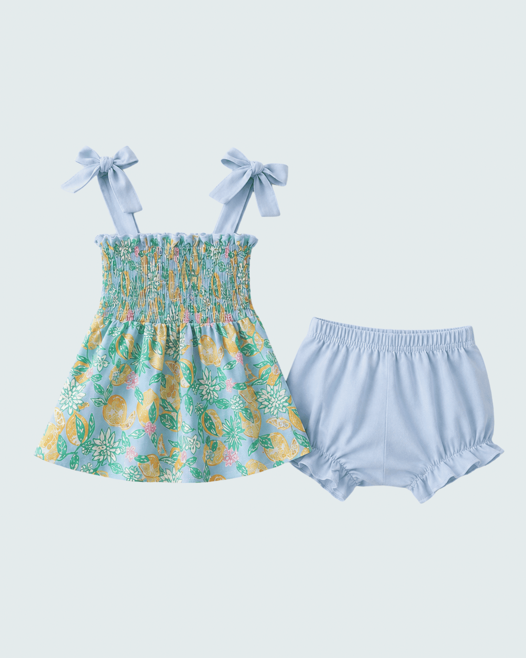 Baby dress with lemon pattern and matching bloomers on a light blue background