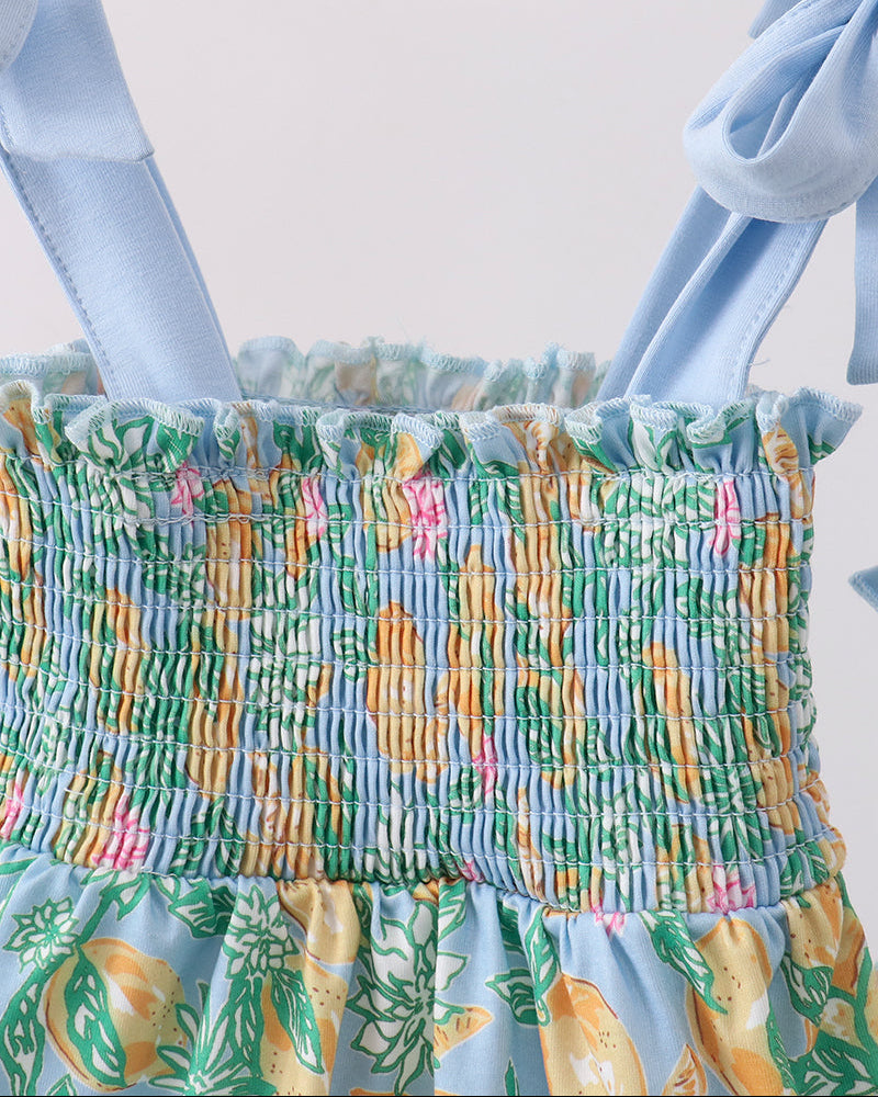 Multicolored smocked top with floral and pineapple pattern on a white background