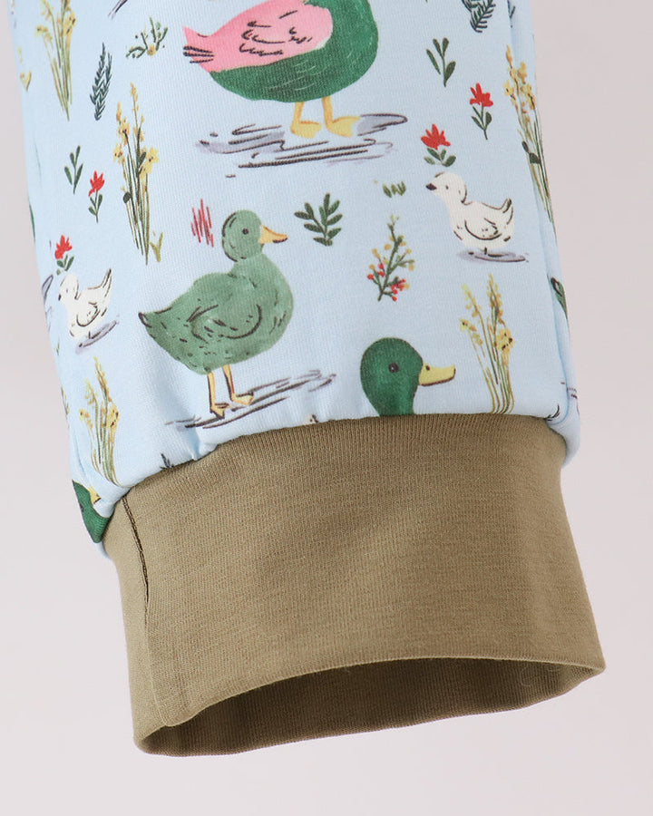 Light blue bird-print pants with olive cuff and stitched hem