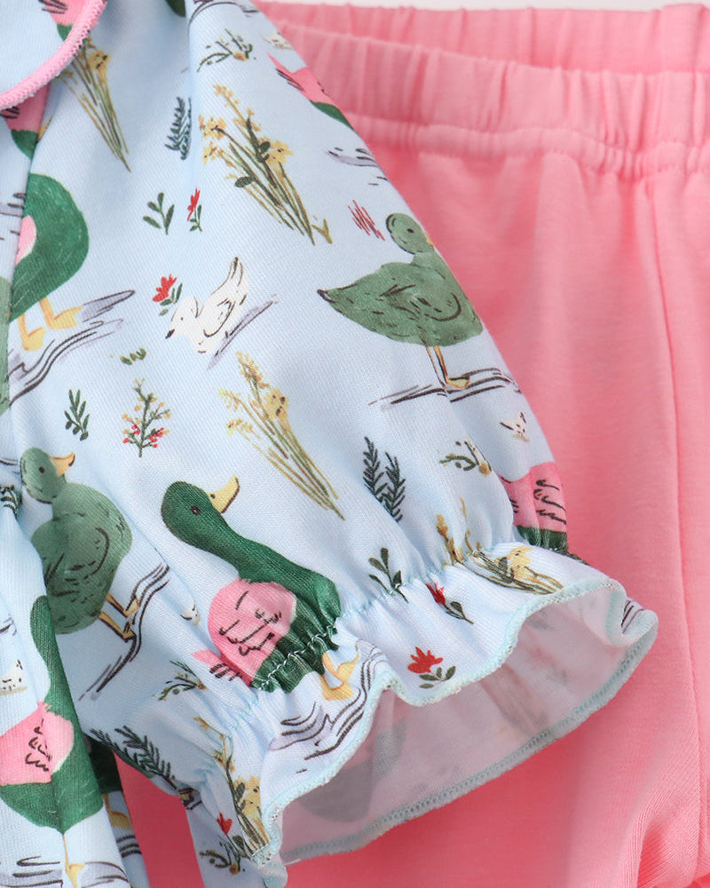 Duck-print top with pink trim and tiered ruffle hem over pink pants