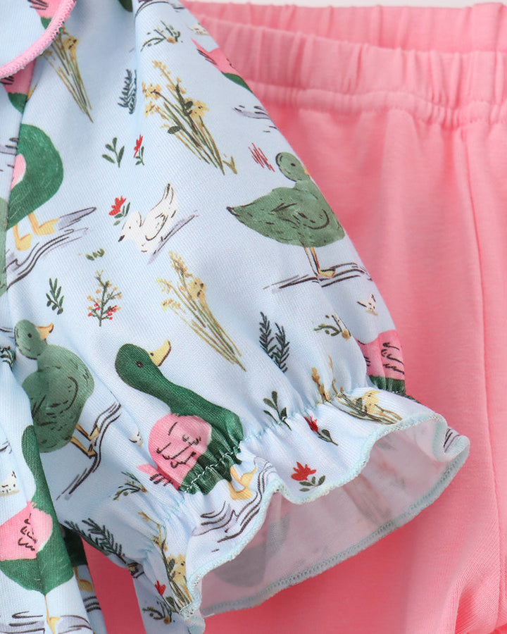 Duck-print top with pink trim and tiered ruffle hem over pink pants