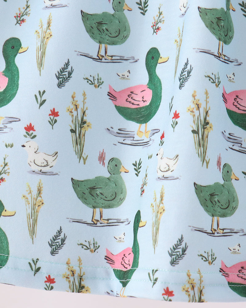 Close-up of light blue fabric with colorful bird and plant pattern