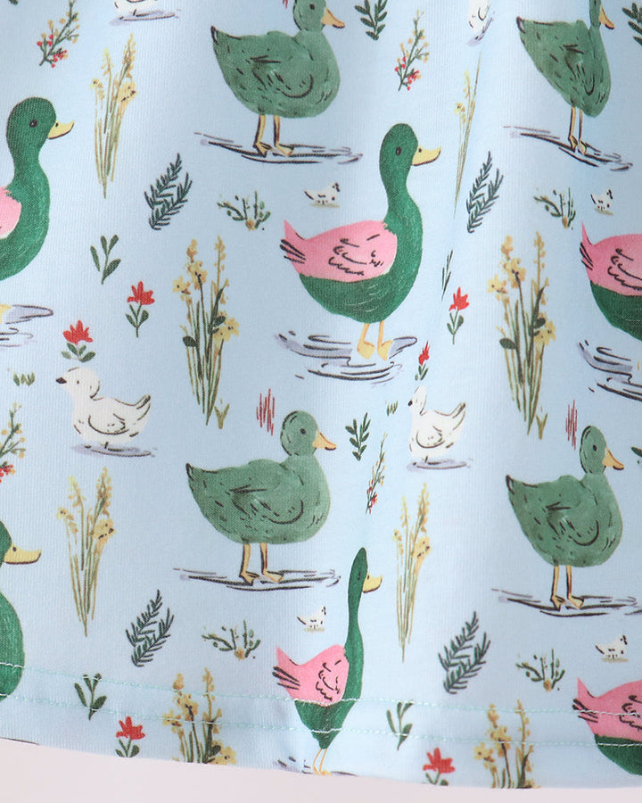 Close-up of light blue fabric with colorful bird and plant pattern