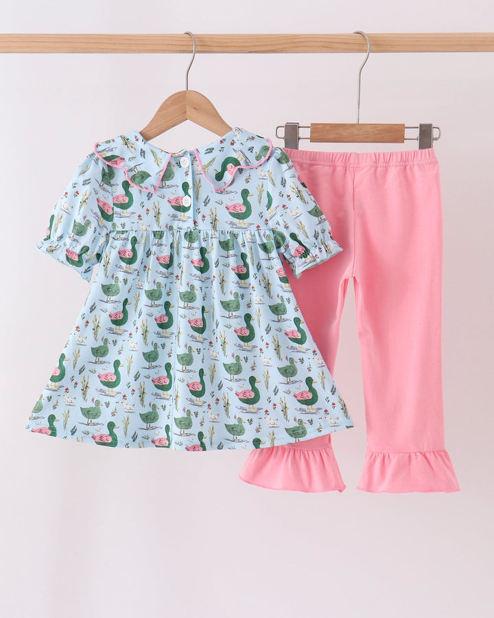 Kids duck-print ruffle top paired with pink ruffle pants on hangers