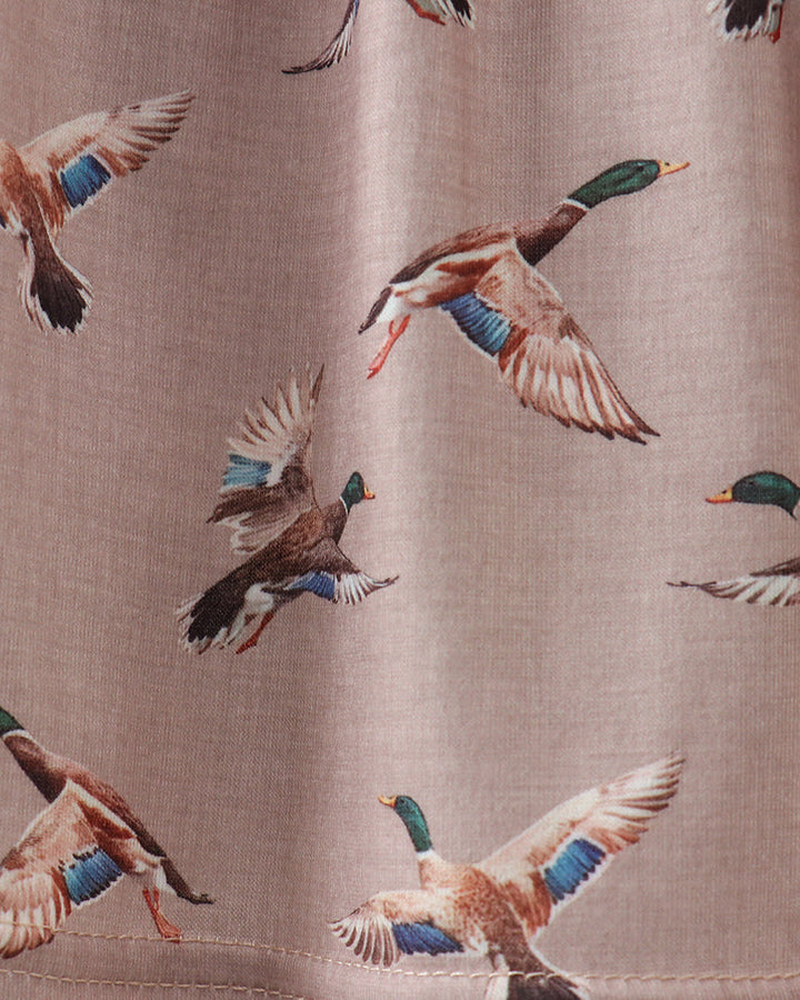Fabric with a pattern of flying ducks on a brown background