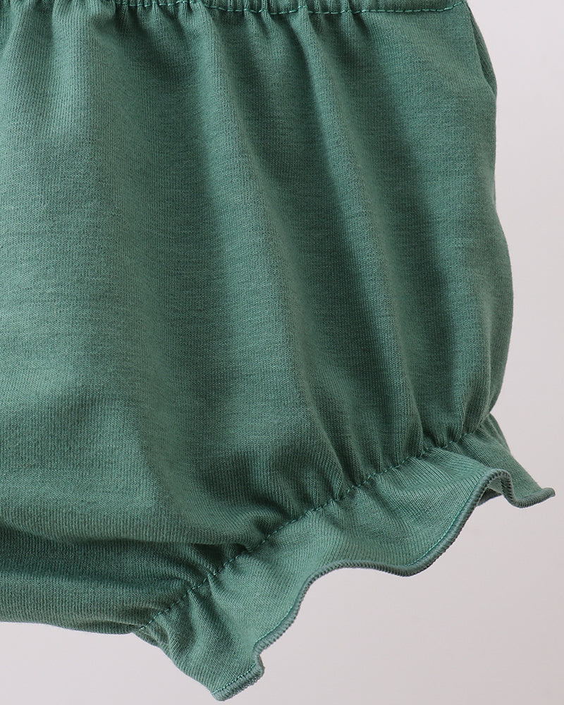 Green baby bloomers on a light gray background