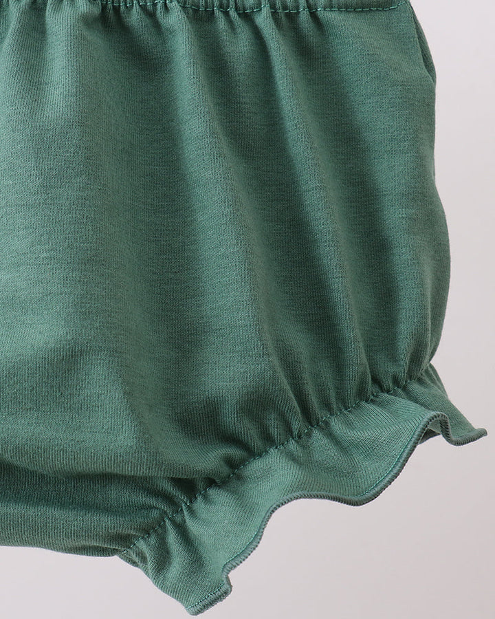 Green baby bloomers on a light gray background
