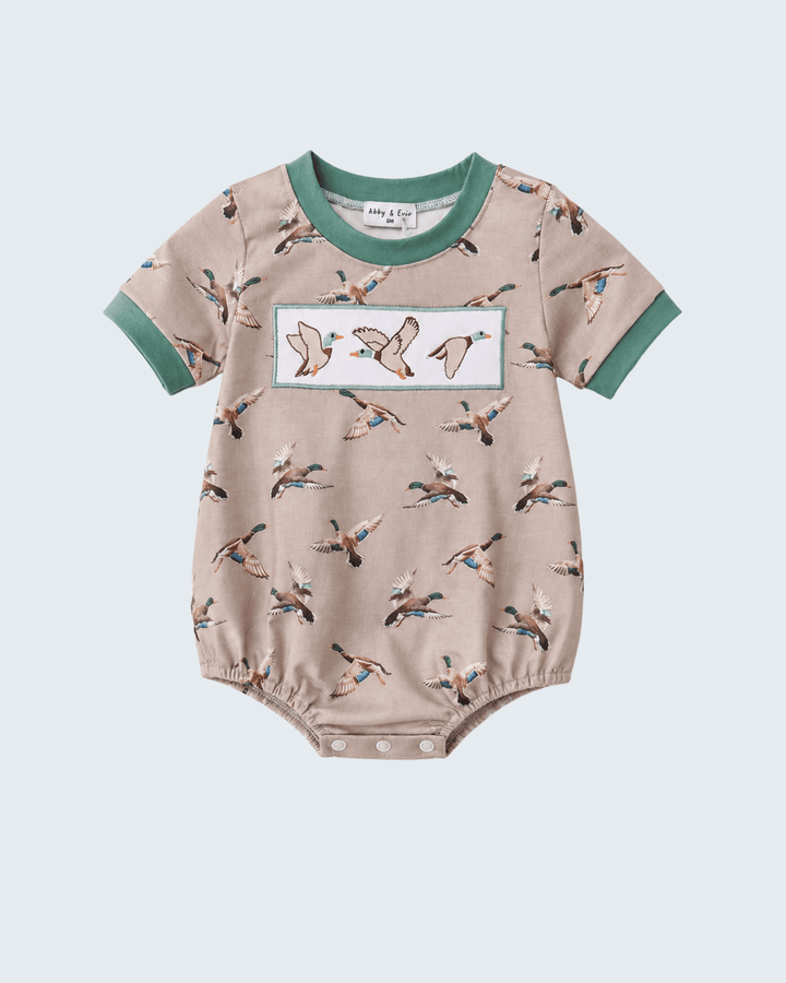 Baby romper with bird pattern on a light gray background