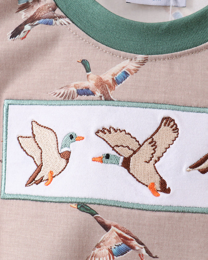 Embroidered design of ducks on a fabric background