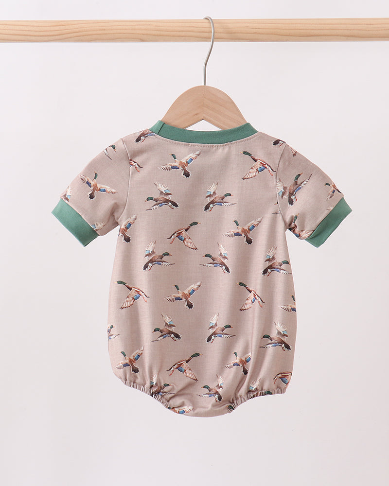 Baby romper with bird pattern on a hanger against a white background