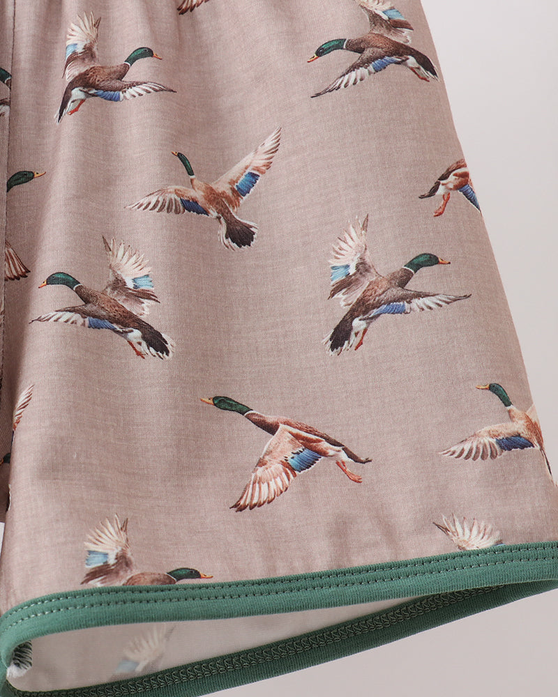 Fabric with duck pattern and green zipper on a neutral background
