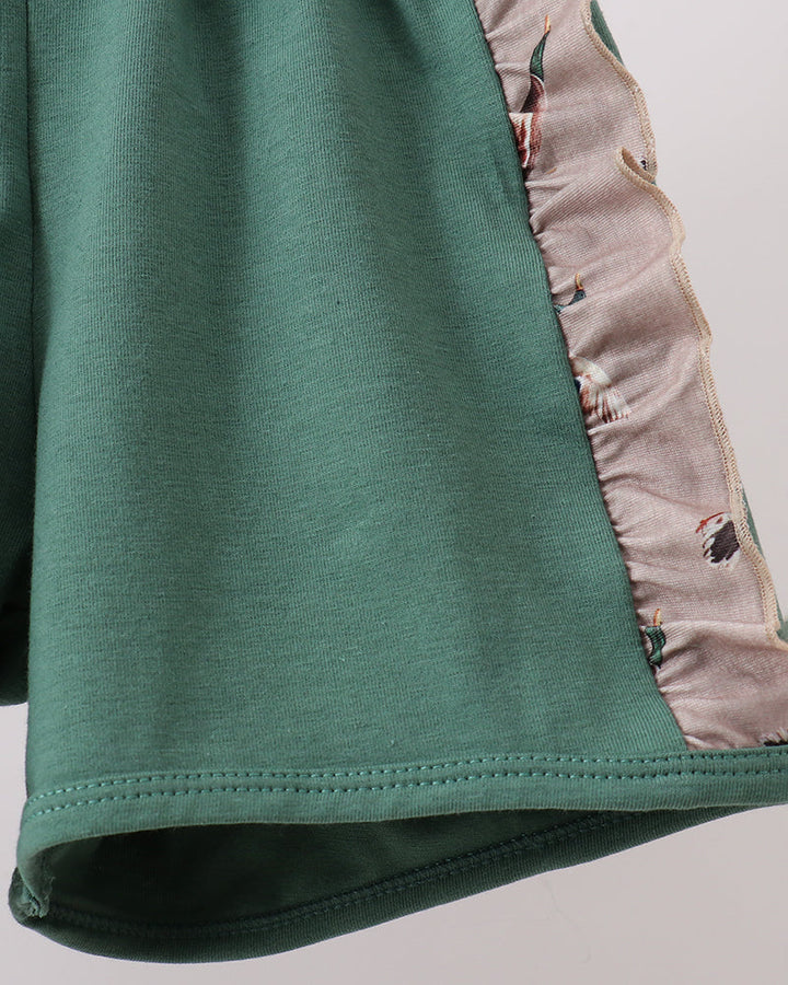 Close-up of a green garment with a patterned lining on a light gray background