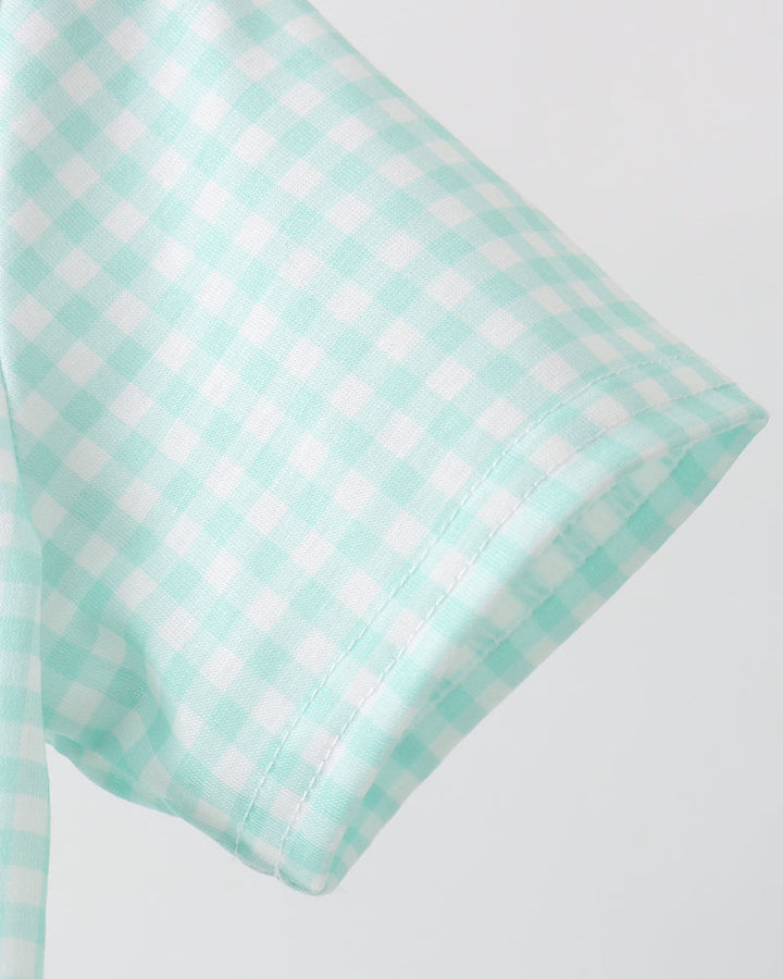 Mint green checkered pillow on a light gray background