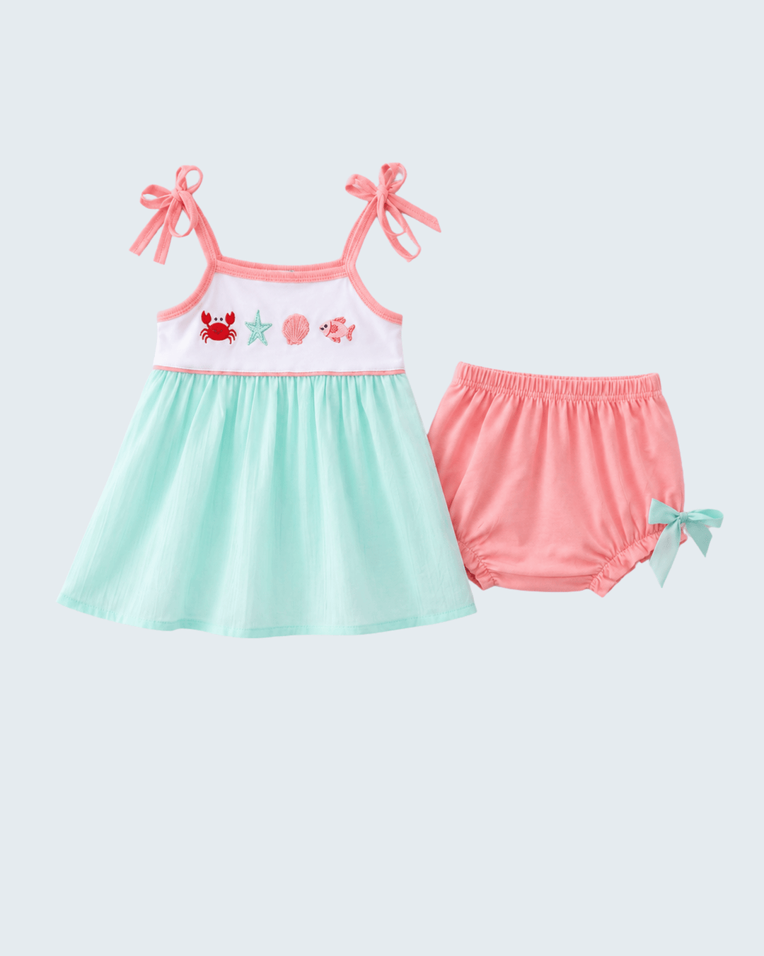 Children's dress with pink straps and green skirt, paired with matching shorts on a light gray background