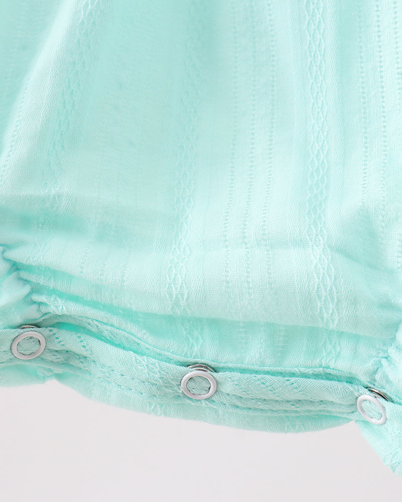 Close-up of a mint green fabric with metal grommets on a white background