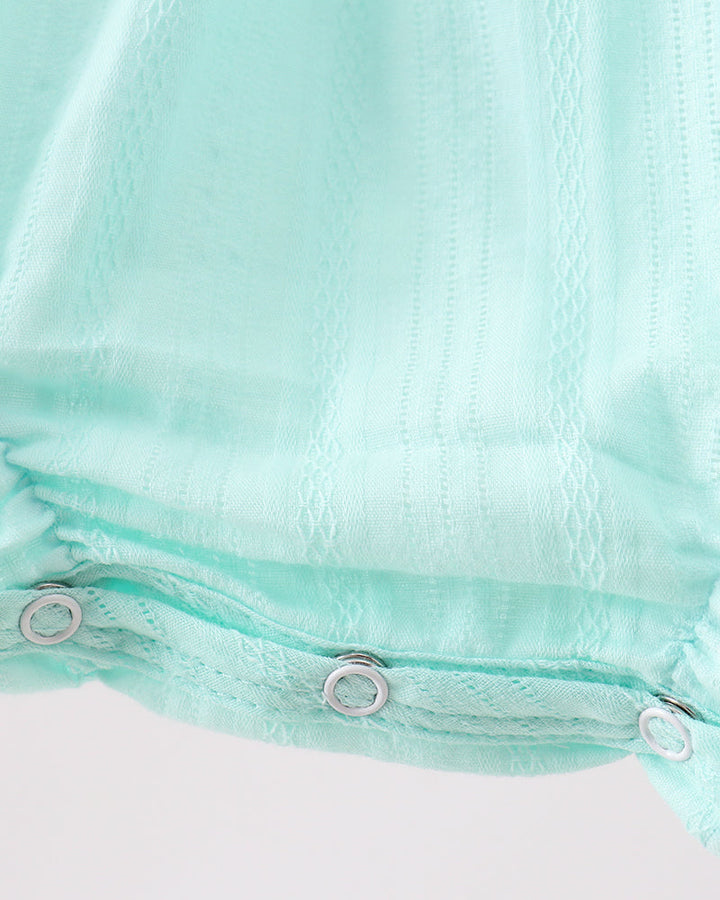 Close-up of a mint green fabric with metal grommets on a white background