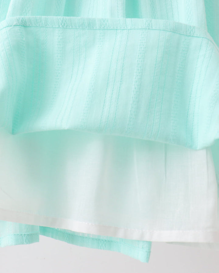 Close-up of a light blue fabric with a subtle pattern on a white background