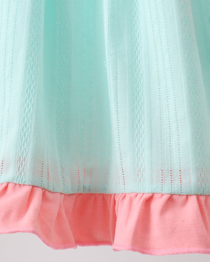 Close-up of a fabric with a light blue top and pink bottom on a gray background
