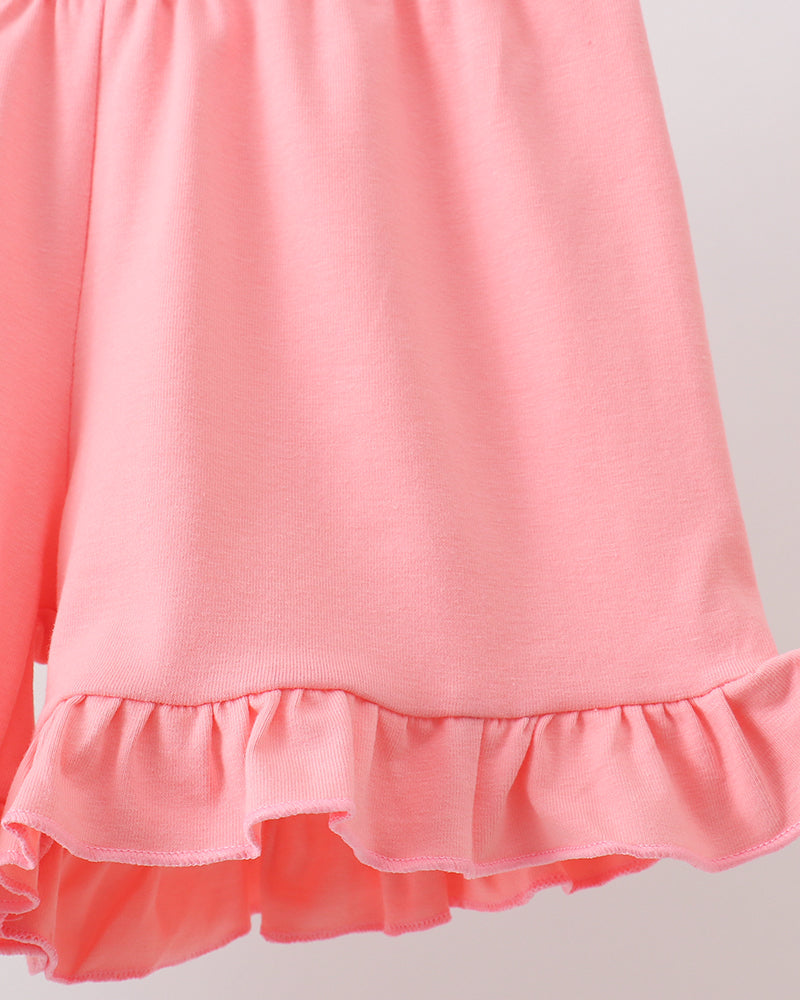 Close-up of a pink shorts with ruffled hem on a light gray background
