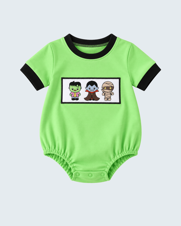 Green short-sleeve bubble romper with black trim, embroidered patch and snap buttons