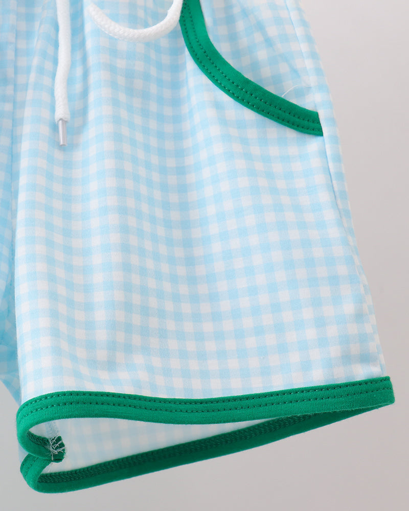 Light blue checkered shorts with green trim on a gray background