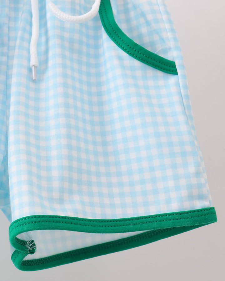 Light blue checkered shorts with green trim on a gray background