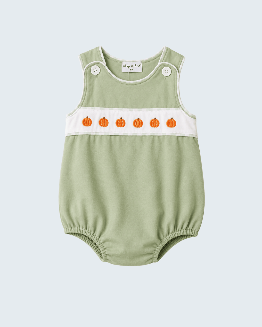A sage green sleeveless baby romper with a white chest band featuring embroidered orange pumpkins, shown on a light gray background.