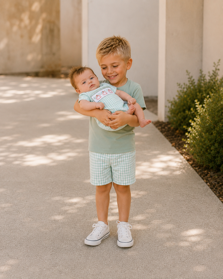 Older brother is carrying baby brother outside.