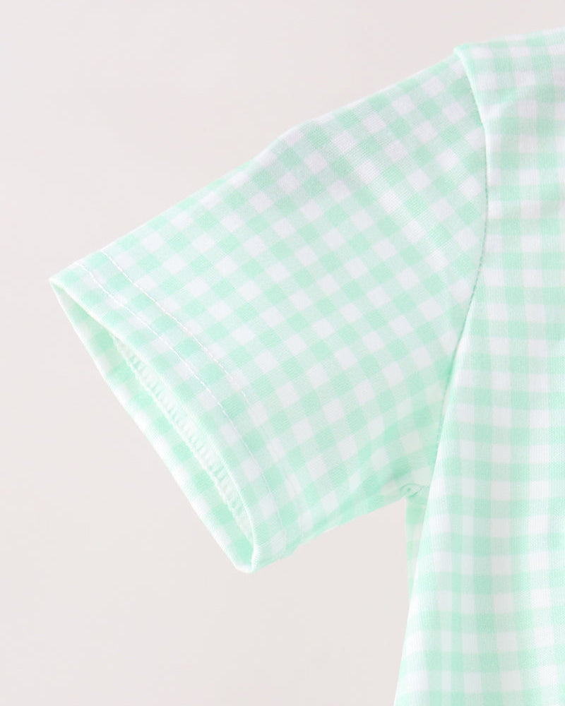 Close-up of a mint green and white gingham patterned short-sleeve garment, showing the fabric texture and collar detail against a plain light background.