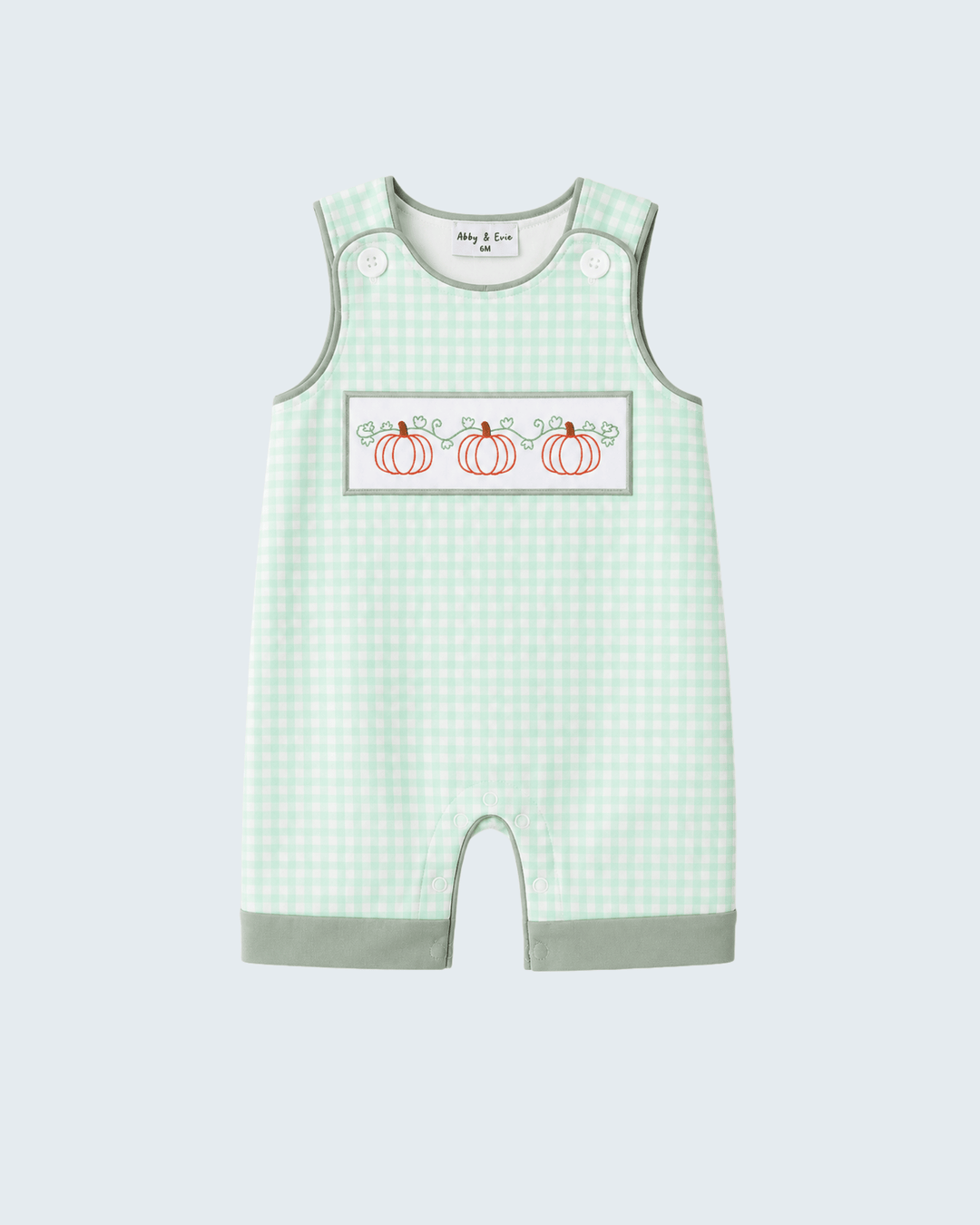 A baby sleeveless romper in a light green and white gingham pattern, featuring a chest patch with three embroidered orange pumpkins and the text &