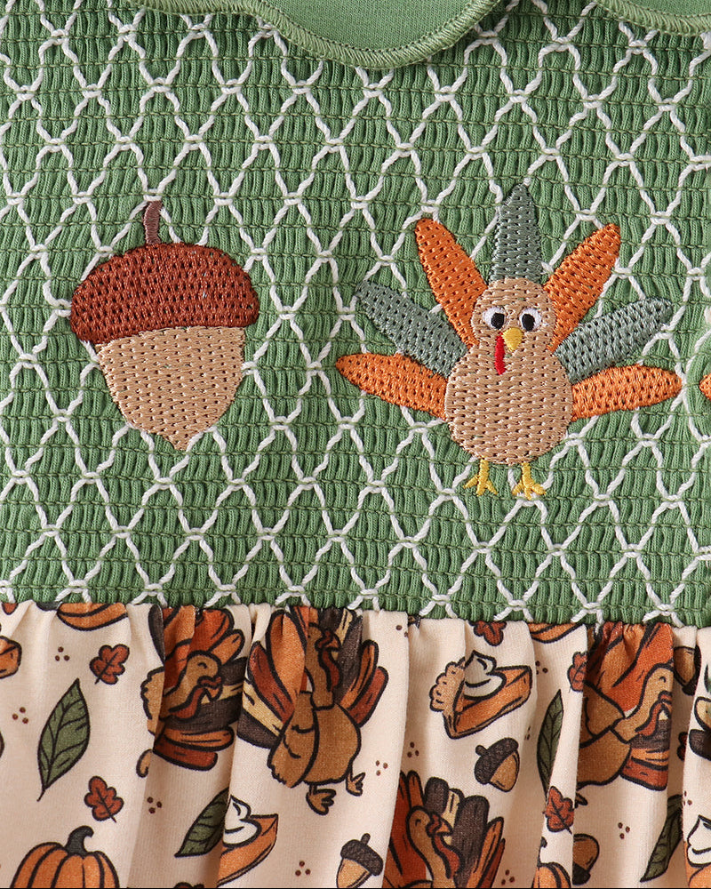 Green smocked yoke with embroidered turkey and pumpkin motifs