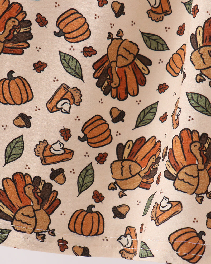 Cream fabric panel with orange and brown turkey, pumpkin, and leaf motifs