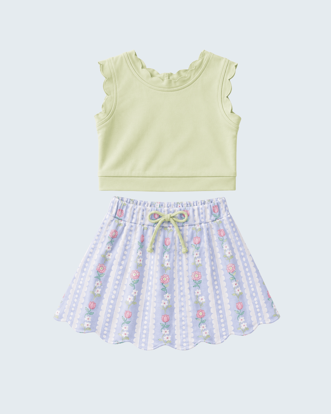 Light green sleeveless top and floral skirt set on a light blue background